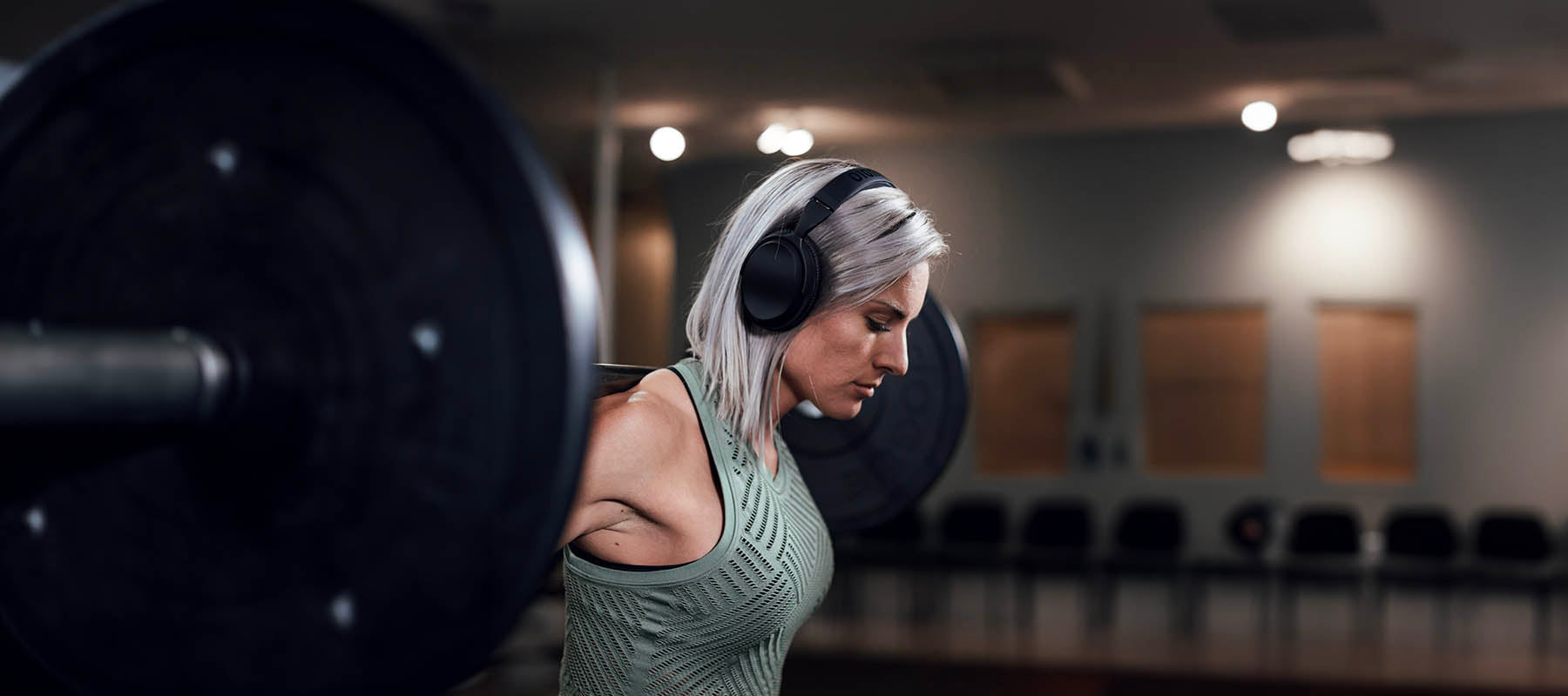 Woman wearing noise cancelling headphones at the gym