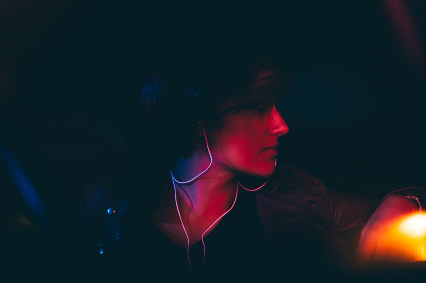Lifestyle image of woman in the dark wearing Bandido earbuds.