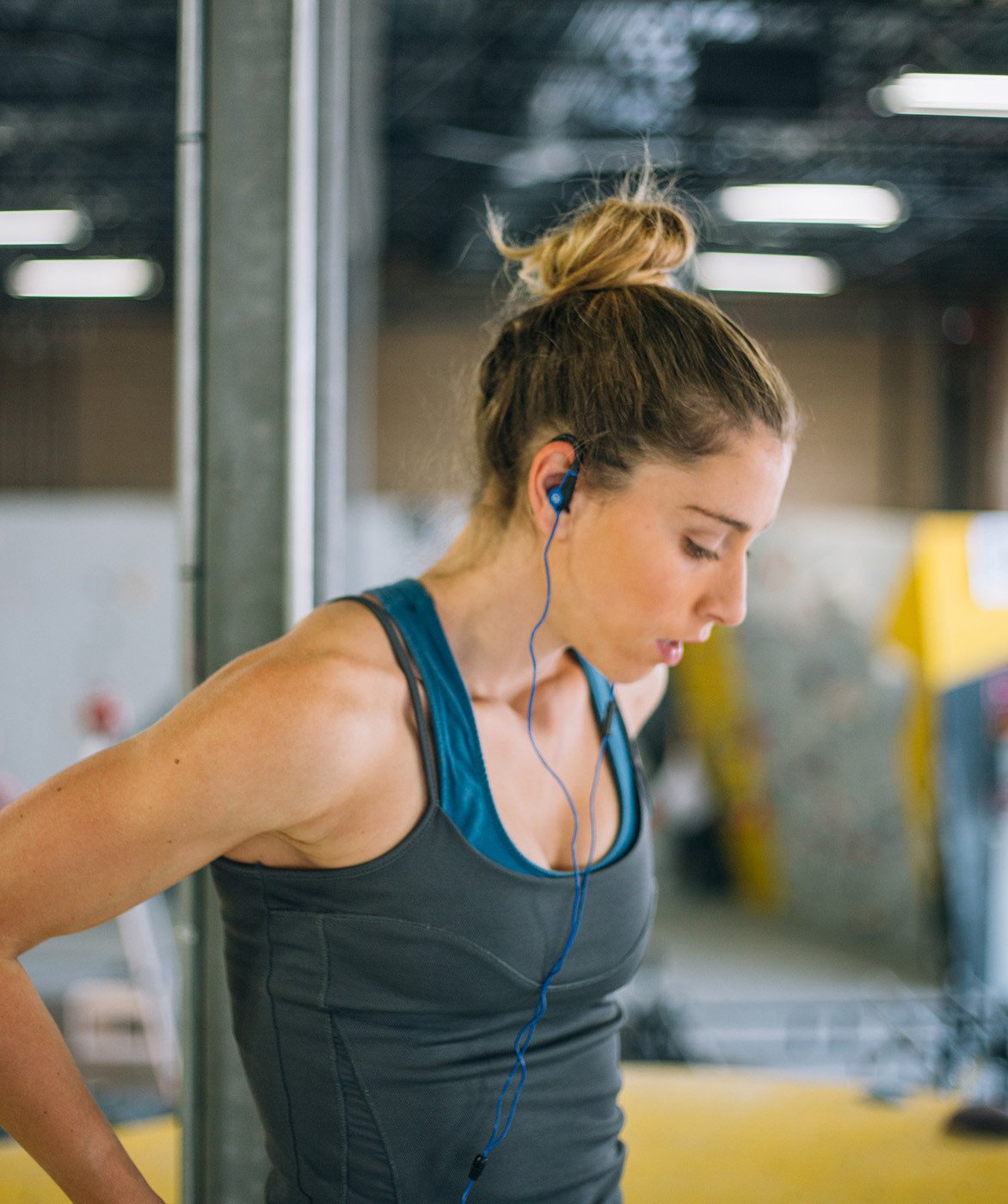 Woman at gym wearing earbuds