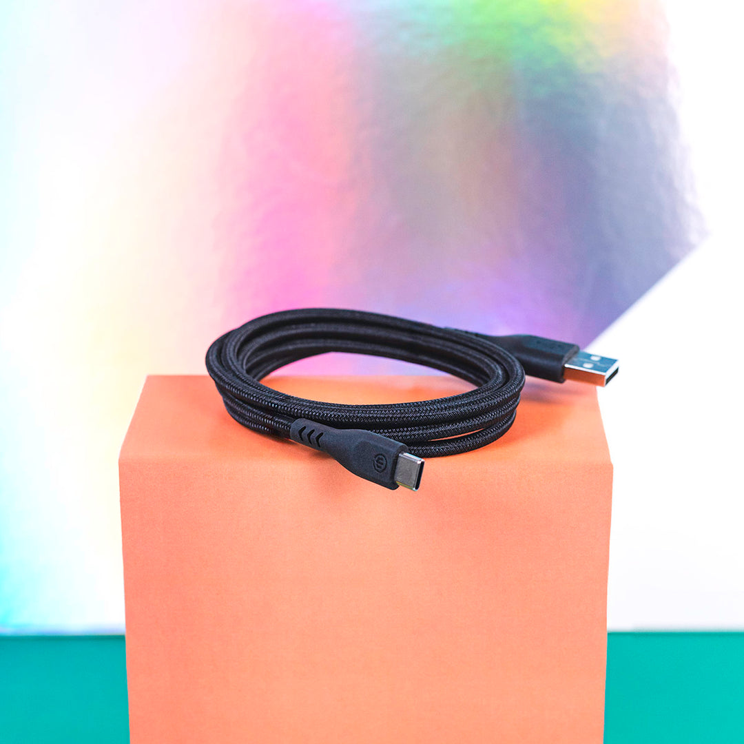 Black charging cable sitting coiled on orange box