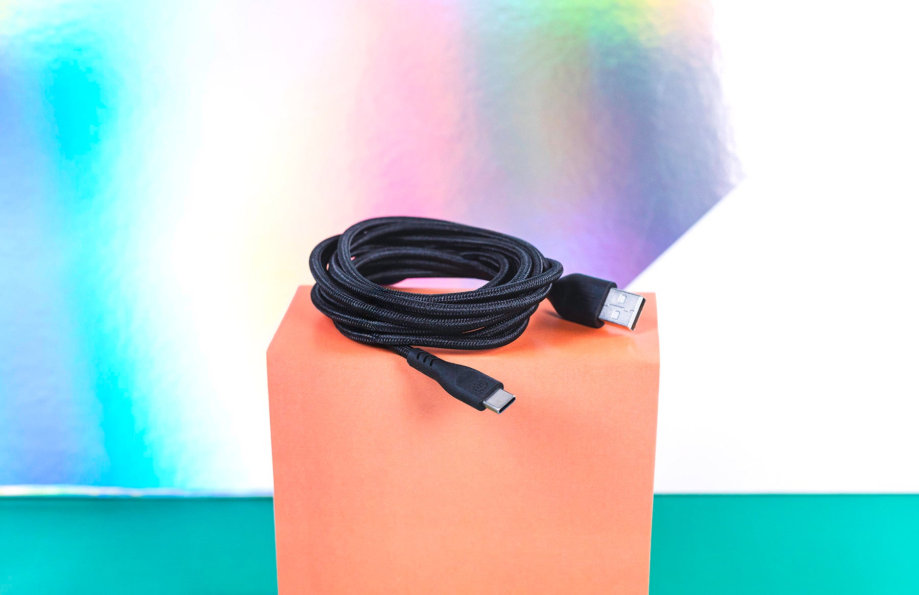 Black charging cable sitting coiled on orange box