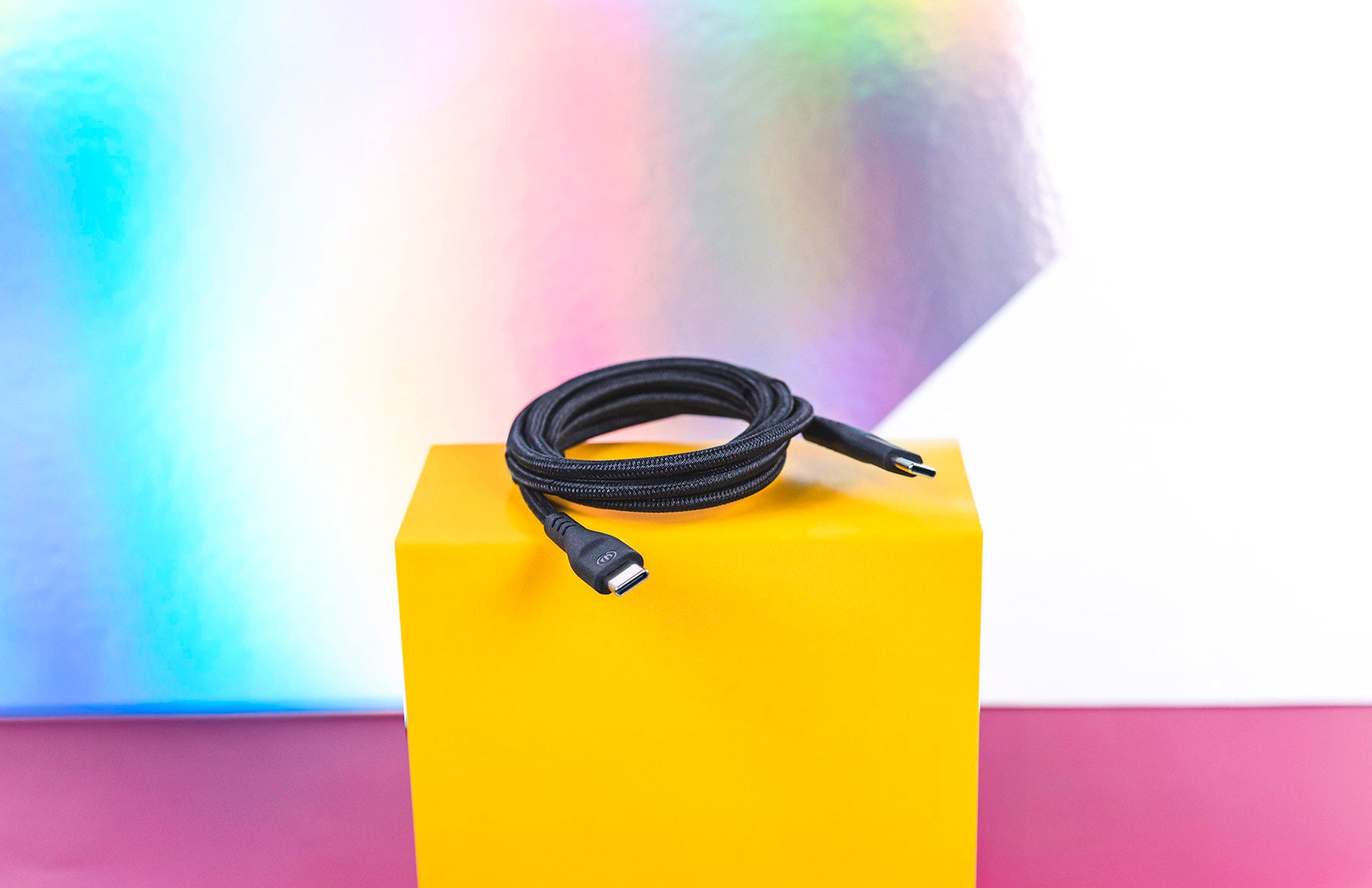 Black charging cable sitting coiled on yellow box