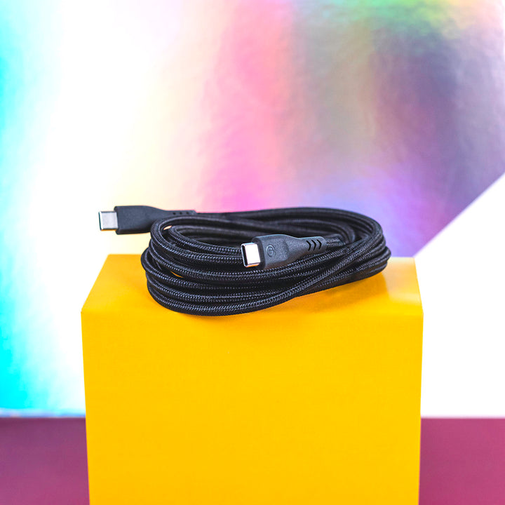 Black charging cable sitting coiled on yellow box