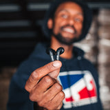 Smiling man holding Mojo 500 earbuds
