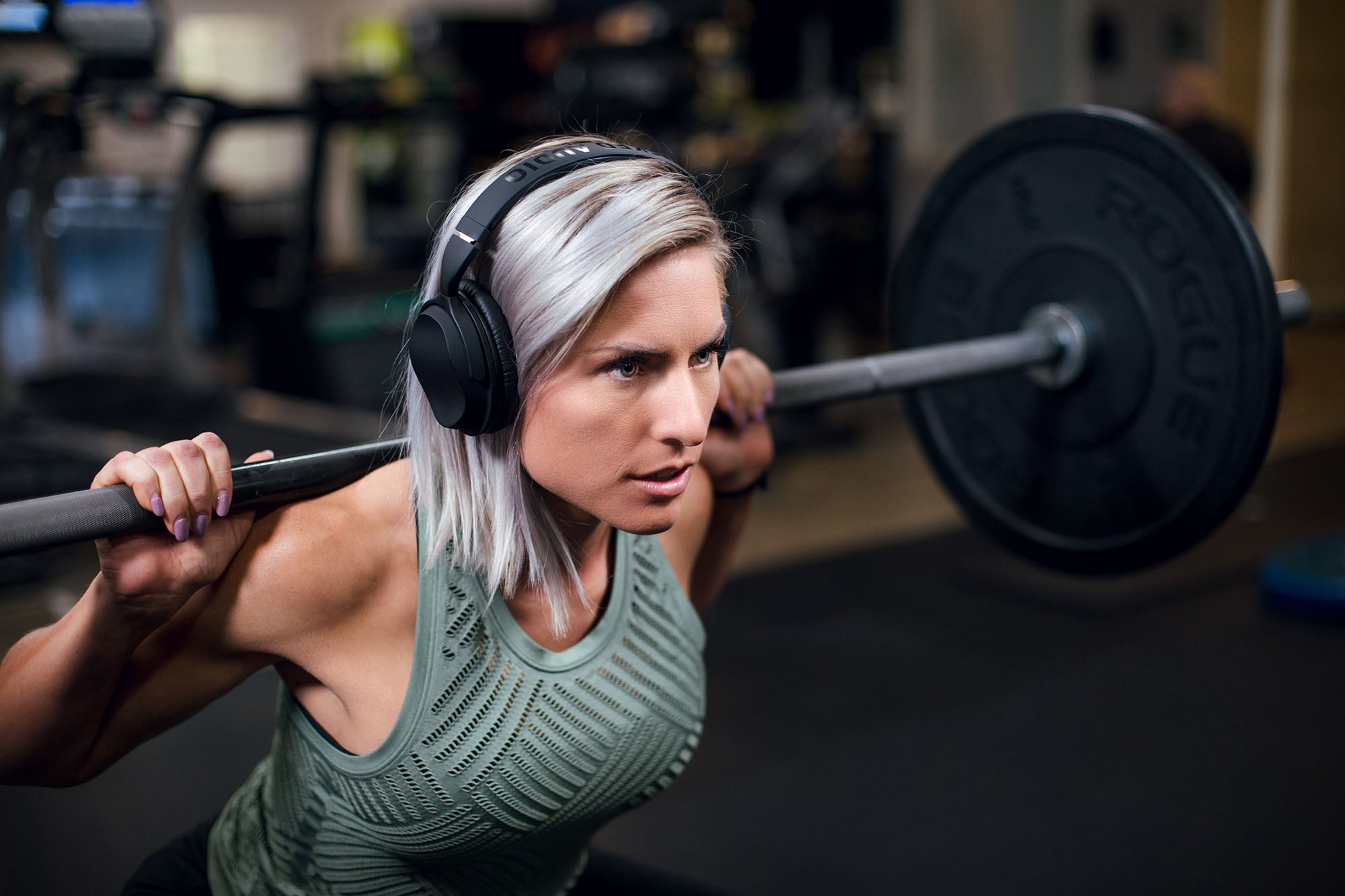Girl with headphones and barbell